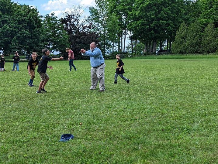 Superintendent Clark catching a water balloon with students. 