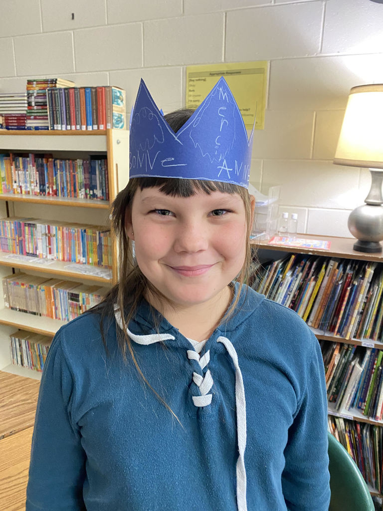 Student in classroom wearing crown