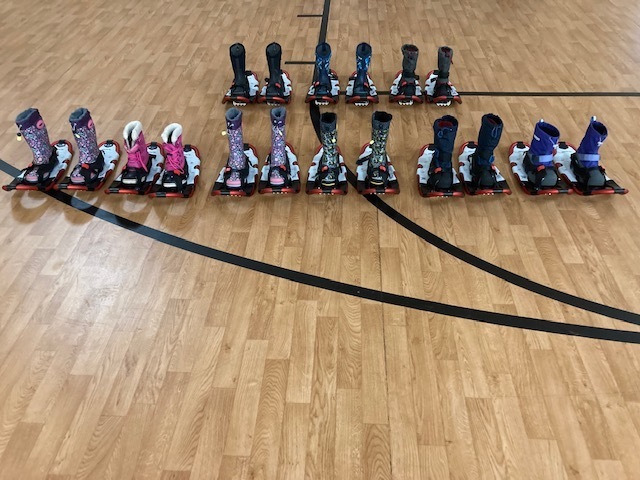 Snowshoes lined up in the gym, ready for students