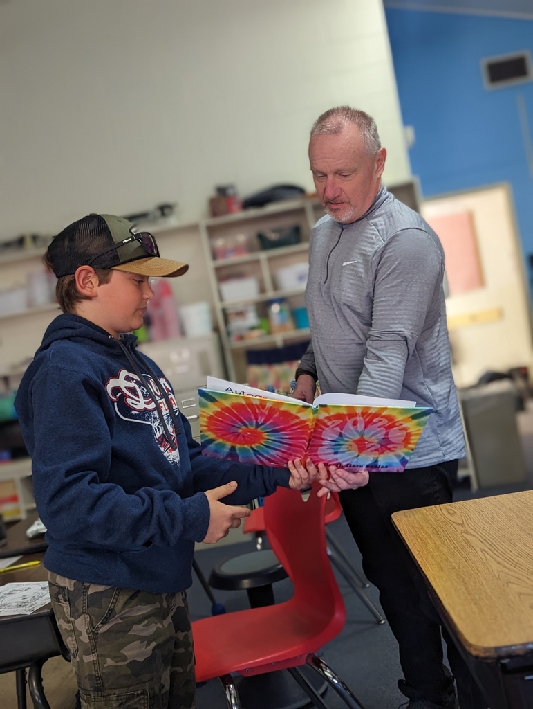 6th grade student presents dedicated yearbook to Mr Hall