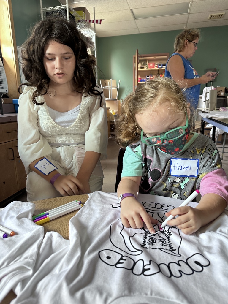 pair of students coloring a t-shirt