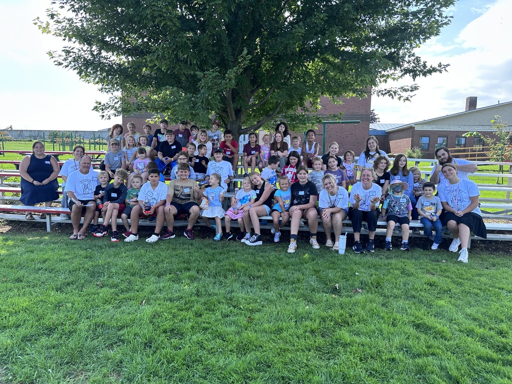 group of all students attending program sitting on benches for a group photo