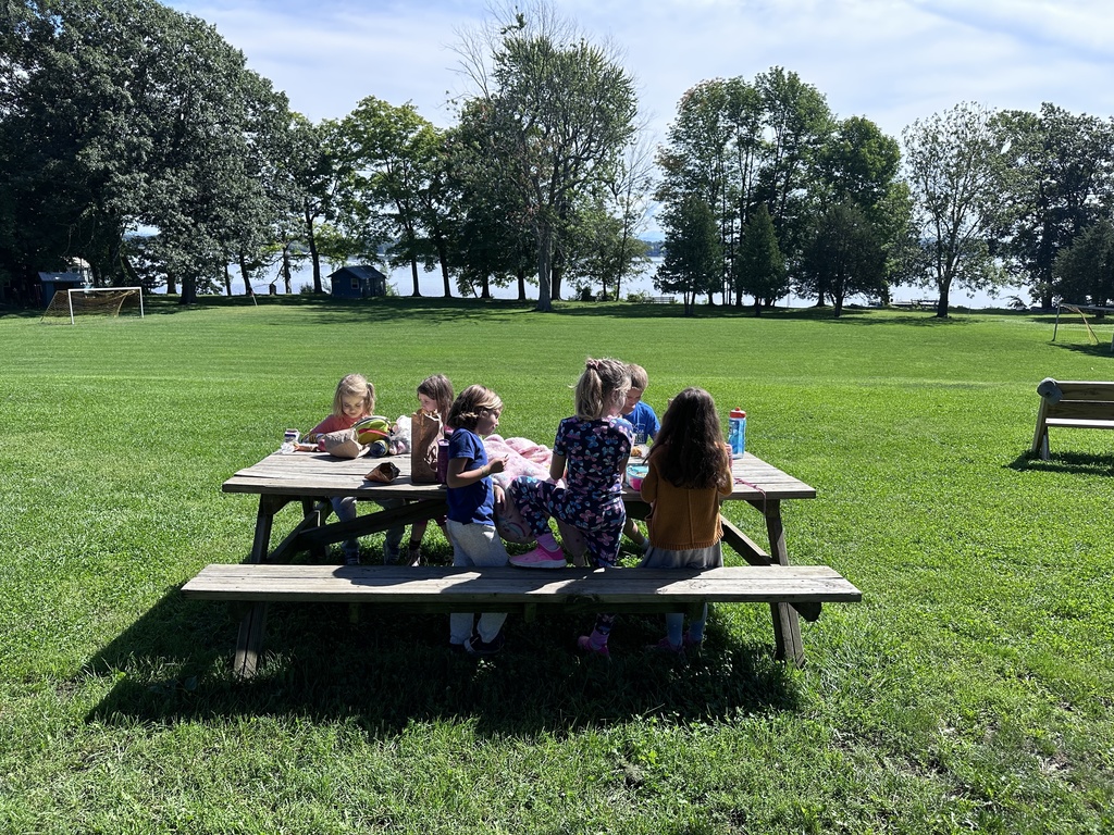 Students sitting at picnic table eating lunch